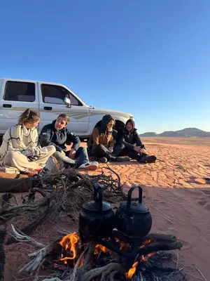 a group of people sitting around a camp fire at Wadi Rum Sunrise Guesthouse in Wadi Rum