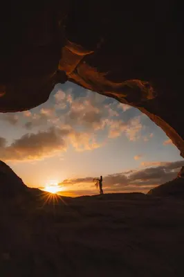 a person standing in the desert looking at the sunset at Wadi Rum Sunrise Guesthouse in Wadi Rum