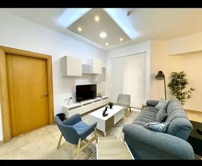 a living room with a blue couch and a tv at Amman damac tower عبدلي عمان دماك Abdali Boulevard in Amman