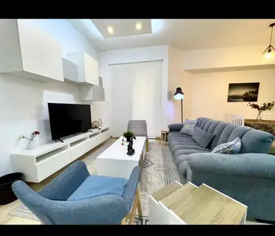 a living room with blue couches and a tv at Amman damac tower عبدلي عمان دماك Abdali Boulevard in Amman
