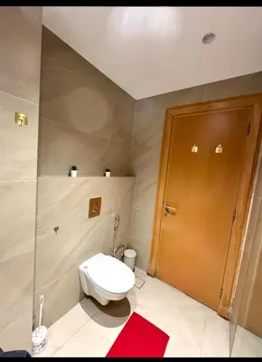 a bathroom with a toilet and a wooden door at Amman damac tower عبدلي عمان دماك Abdali Boulevard in Amman