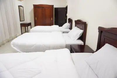 a group of white beds in a room at النخيل للشقق الفندقية ALnakheel hotel apartment in Aqaba