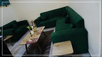 a living room with a green couch and a table at النخيل للشقق الفندقية ALnakheel hotel apartment in Aqaba