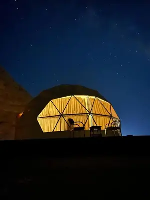 a large dome tent with two chairs in it at night at Gakleen luxury camp in Aqaba