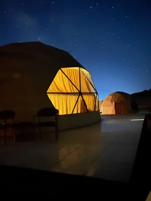 a lit up tent in a desert at night at Gakleen luxury camp in Aqaba