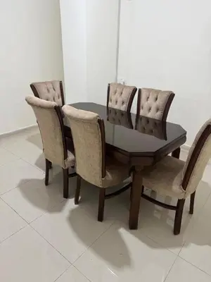 a dining room table with three chairs and a table at Bonuk House in Kufayrāt Abū Khīnan