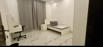 a white room with a desk with a tv on it at Cozy, Newly Furnished & Budget Friendly Apartment in Amman