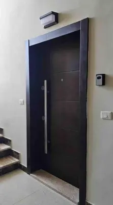 a black door in a building with a light on it at Cozy, Newly Furnished & Budget Friendly Apartment in Amman