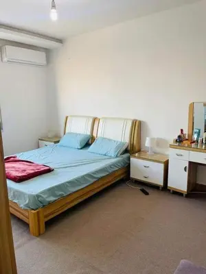 a bedroom with a bed with blue sheets and a mirror at نسيم الرمثاء in Ar Ramthā