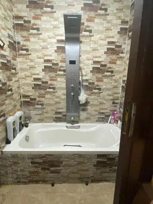 a bath tub in a bathroom with a stone wall at نسيم الرمثاء in Ar Ramthā