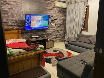 a living room with a bed and a tv on a brick wall at نسيم الرمثاء in Ar Ramthā