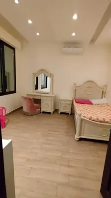 a bedroom with two beds and a mirror at منتجع وفيلا تل الرمان in Ar Rummān