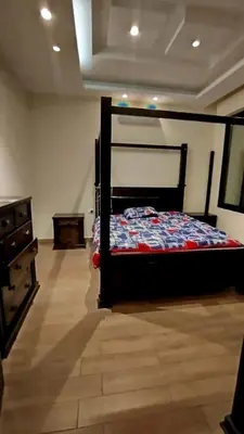 a bedroom with a bed and a wooden floor at منتجع وفيلا تل الرمان in Ar Rummān
