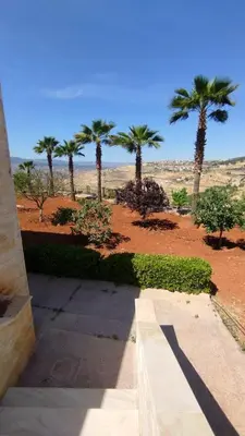 a view of a park with palm trees and a sidewalk at منتجع وفيلا تل الرمان in Ar Rummān
