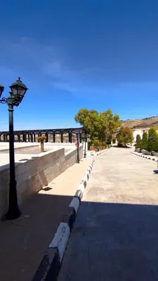 a sidewalk with a street light next to a wall at منتجع وفيلا تل الرمان in Ar Rummān