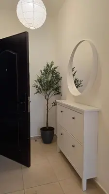 a room with a mirror and a dresser with a tree at Modern One Bedroom with Steps from the Best Shops in Amman