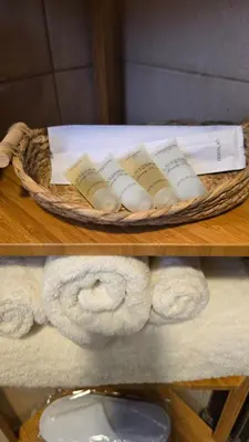 a basket of towels and books on a shelf at Modern One Bedroom with Steps from the Best Shops in Amman
