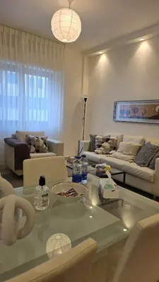 a living room with a couch and a table at Modern One Bedroom with Steps from the Best Shops in Amman