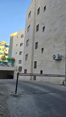 a stone building with a fence in front of it at Modern One Bedroom with Steps from the Best Shops in Amman