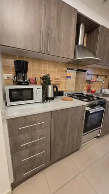 a kitchen with a microwave and a stove at Modern One Bedroom with Steps from the Best Shops in Amman