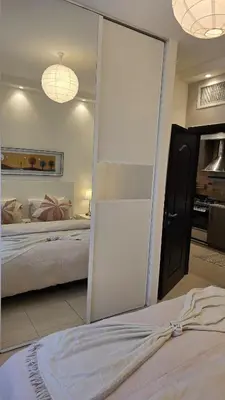 a bedroom with a mirror and a bed in it at Modern One Bedroom with Steps from the Best Shops in Amman