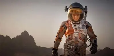 a man in an astronaut suit standing on a field at Faraj wadi rum in Disah