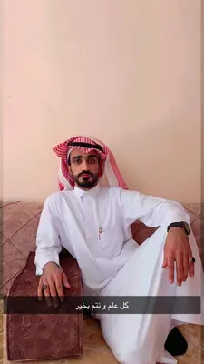 a man dressed in white sitting on a bench at Faraj wadi rum in Disah