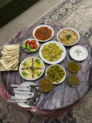 a table with plates of food on a table at Sewar hostel in Petra