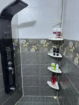 a shower with three shelves in a bathroom at Sewar hostel in Petra