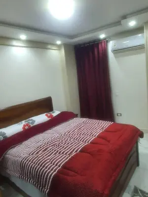 a bedroom with a bed with a red blanket at عبق التاريخ هاوس in Rujm al Ḩāwī
