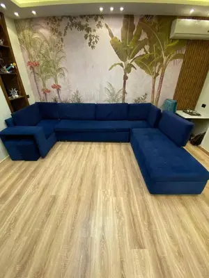 a blue couch sitting in a living room at عبق التاريخ هاوس in Rujm al Ḩāwī