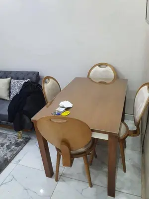 a wooden table with two chairs and a table and a couch at عبق التاريخ هاوس in Rujm al Ḩāwī