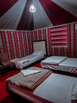 a room with three beds in a tent at Desert Sands Camp Wadi Rum in Wadi Rum