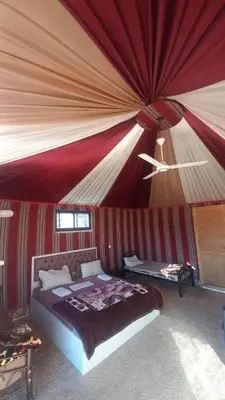 a bedroom with a bed with a red ceiling at Desert Sands Camp Wadi Rum in Wadi Rum