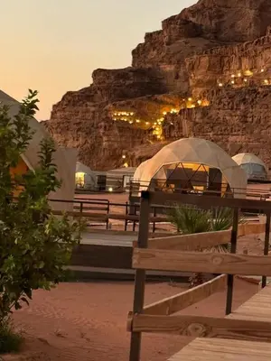 a group of benches in front of a mountain at Desert Sands Camp Wadi Rum in Wadi Rum