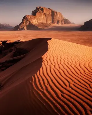 a desert with a mountain in the background at Desert Sands Camp Wadi Rum in Wadi Rum