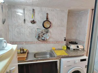 a kitchen with a sink and a washing machine at بيت الحجر in Amman