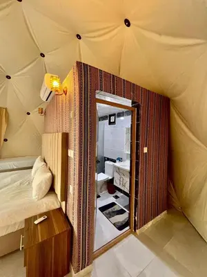 a room with a bed and a mirror in a tent at Suleman Bedouin Life Camp in Wadi Rum