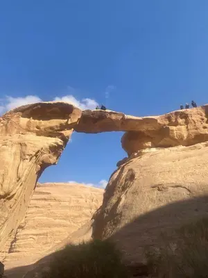 a rock arch in the desert with a blue sky at Suleman Bedouin Life Camp in Wadi Rum