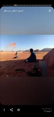 a man sitting on a rock on the beach at Wadi Rum Hiking &camp in Wadi Rum