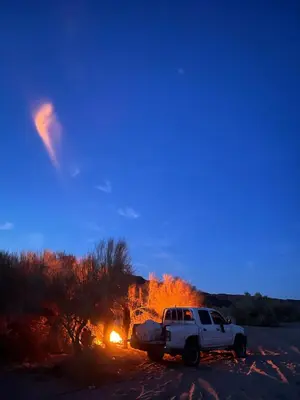 a white truck parked in front of a fire at Wadi rum fasial camp in Wadi Rum