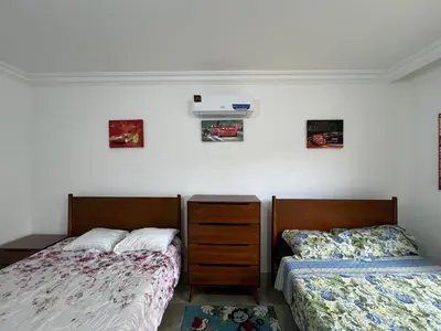 a bedroom with two beds and a air conditioner on the wall at Luxury spacious house in dabouq with parking in Amman