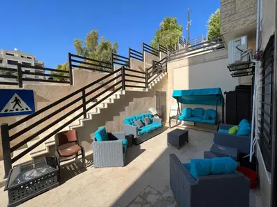 a patio with couches and chairs next to a staircase at Luxury spacious house in dabouq with parking in Amman