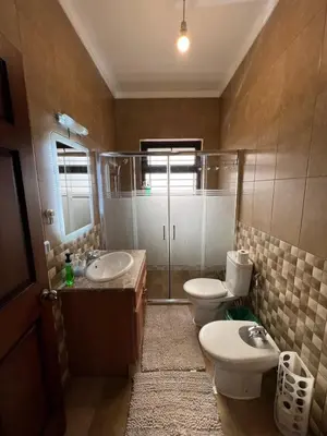 a bathroom with two toilets and a sink and a shower at Luxury spacious house in dabouq with parking in Amman