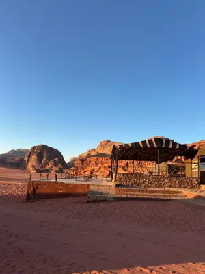 a building in the desert with mountains in the background at Desert Star Camp in Wadi Rum