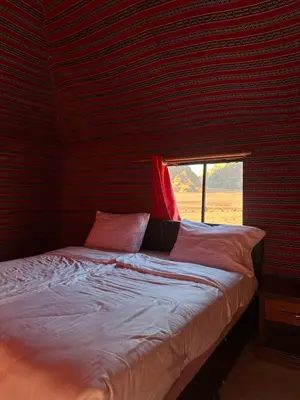 a bed in a room with a window at Desert Star Camp in Wadi Rum