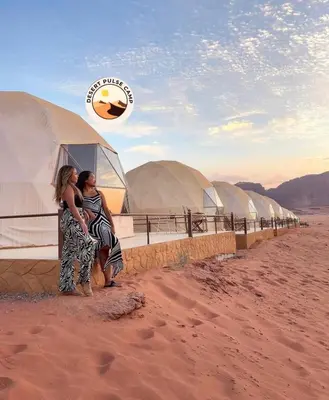 two women standing in front of domes in the desert at RUM BULSE BUBBLE lUXURY CAMP in Disah