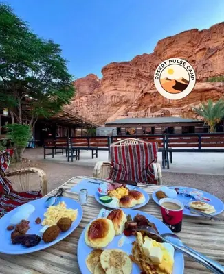 a table with plates of breakfast food on it at RUM BULSE BUBBLE lUXURY CAMP in Disah