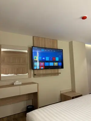 a room with a bed and a flat screen tv on the wall at Ailana Hotel in Aqaba