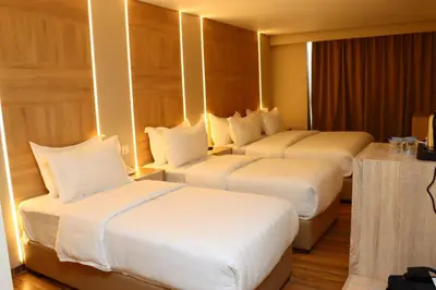 two beds in a hotel room with white pillows at Ailana Hotel in Aqaba